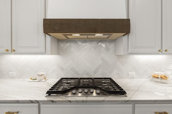 Gas cooktop under the cedar-trimmed vent hood