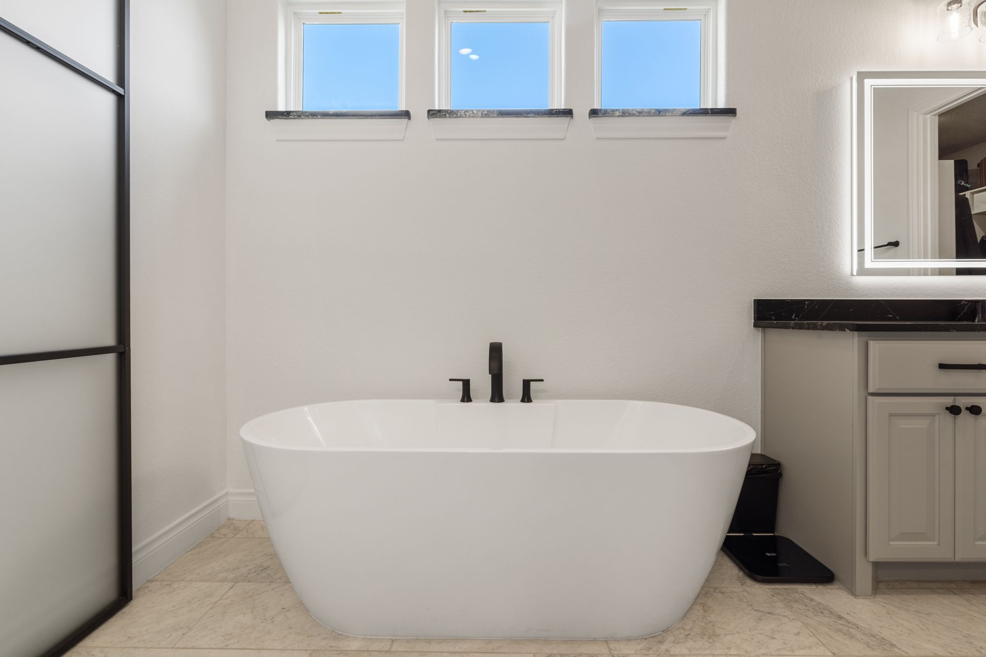 Primary bath with a freestanding tub under clerestory windows