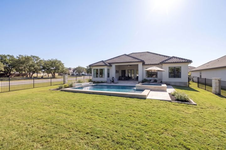 Concept rendering: the back yard with the live oaks removed, a pool and spa, travertine deck and a wrought iron fence; the corner side opens to the street